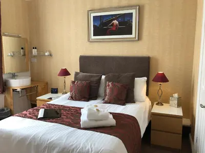 a hotel room with a bed with towels on it at Adelphi Guest House in Southport