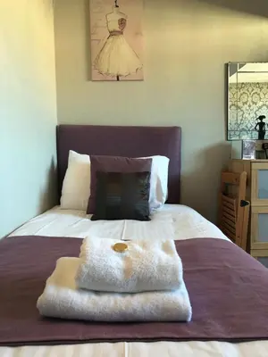 a bed with a white towel on top of it at Adelphi Guest House in Southport