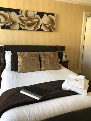 a bedroom with a bed with a book on it at Adelphi Guest House in Southport