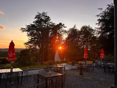 a group of tables with umbrellas in front of the sunset at Uplands Inn Cartmel in Cartmel