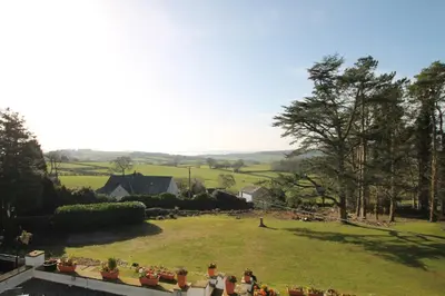 a group of people sitting in a large grass field at Uplands Inn Cartmel in Cartmel