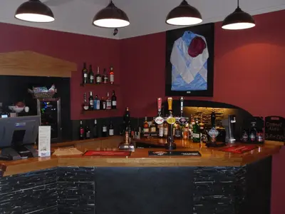 a bar in a room with bottles of alcohol at Priory hotel in Cartmel