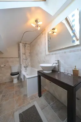 a bathroom with a sink and a tub and a toilet at Priory hotel in Cartmel