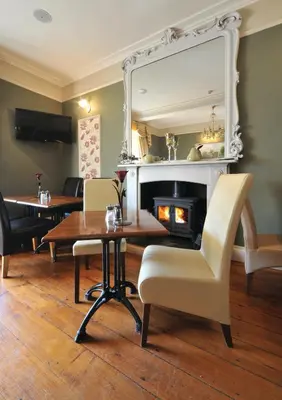 a dining room with a table and a mirror at Priory hotel in Cartmel