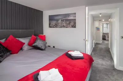 a bedroom with a bed with red and white pillows at 2 Bedrooms Sleeps 6 Near Top Blackpool Attractions in Blackpool