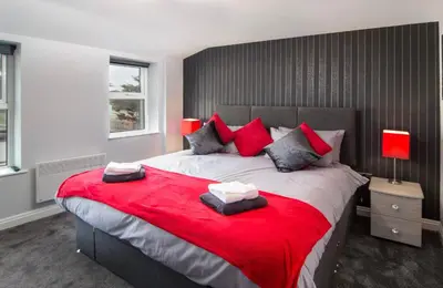 a bedroom with a large bed with a red blanket at 2 Bedrooms Sleeps 6 Near Top Blackpool Attractions in Blackpool
