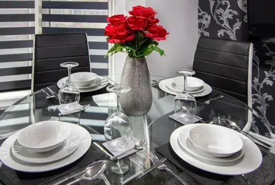 a glass table with a vase with red roses in it at 2 Bedrooms Sleeps 6 Near Top Blackpool Attractions in Blackpool