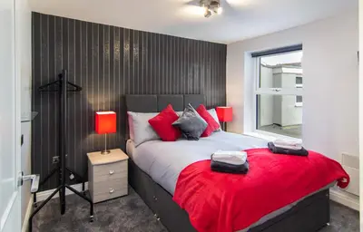 a bedroom with a large bed with red pillows at 2 Bedrooms Sleeps 6 Near Top Blackpool Attractions in Blackpool