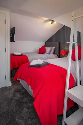 a bedroom with two beds with red blankets at 2 Bedrooms Sleeps 6 Near Top Blackpool Attractions in Blackpool