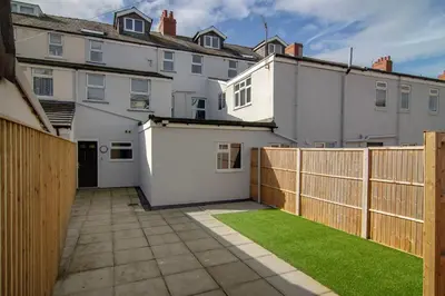a backyard with a fence and green grass at 2 Bedrooms Sleeps 6 Near Top Blackpool Attractions in Blackpool
