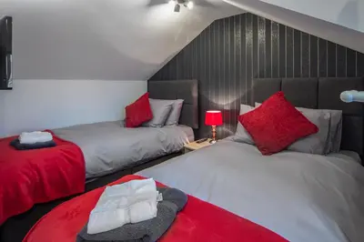 two beds with red pillows in a room at 2 Bedrooms Sleeps 6 Near Top Blackpool Attractions in Blackpool