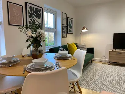 a living room with a wooden table and chairs at Womack Lodge in Saint Helens