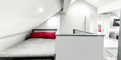 a bedroom with a red bed in a white room at The Anfield Rooms in Liverpool