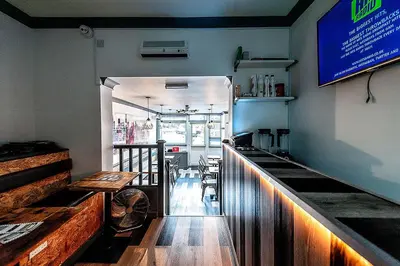 a bar in a restaurant with a table and chairs at The Anfield Rooms in Liverpool