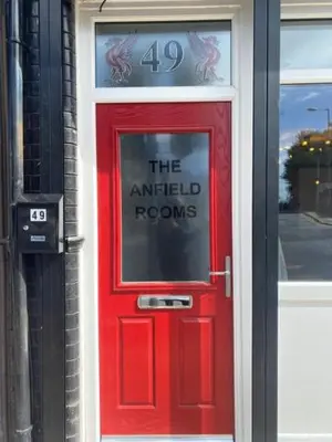 a red door with a sign on top of it at The Anfield Rooms in Liverpool