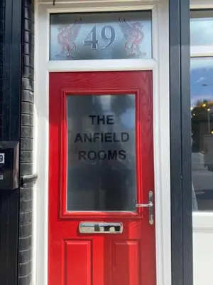 a red door with a sign on top of it at The Anfield Rooms in Liverpool