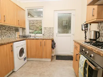 a kitchen with a washing machine and a washer and dryer at Cosy Bee in Morecambe