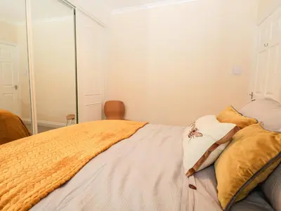 a bedroom with a bed with a mirror on it at Cosy Bee in Morecambe