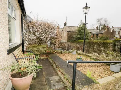 a garden with a bench and plants in a yard at Cosy Bee in Morecambe