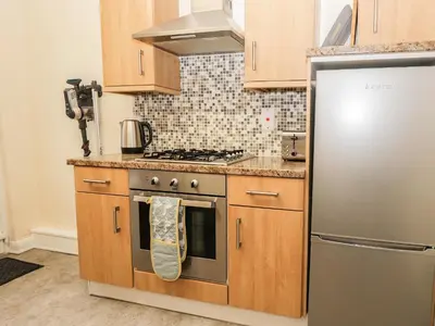 a kitchen with a stove and a refrigerator at Cosy Bee in Morecambe