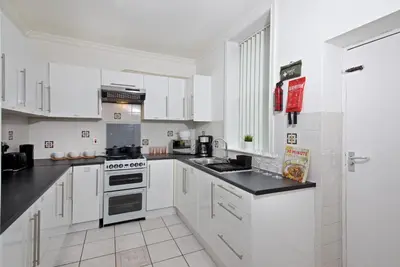 a white kitchen with white cabinets and black counter tops at Liverpool City Stays - Economy Room Close to city centre GG in Liverpool