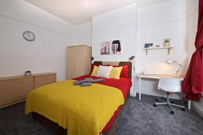 a bedroom with a yellow and red bed and a desk at Liverpool City Stays - Economy Room Close to city centre GG in Liverpool