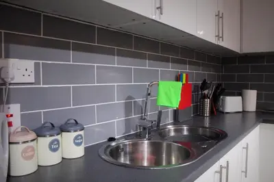 a kitchen counter with a stainless steel sink at The Place by the Sea in Blackpool