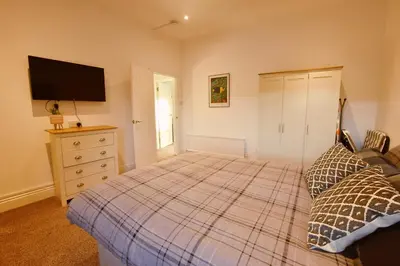 a bedroom with a bed and a tv on the wall at The Place by the Sea in Blackpool
