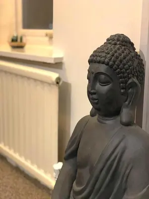 a statue of a buddha sitting in a room at The Place by the Sea in Blackpool
