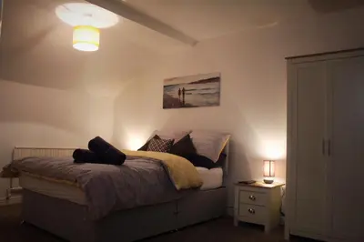 a bedroom with a bed with a lamp and a night stand at The Place by the Sea in Blackpool