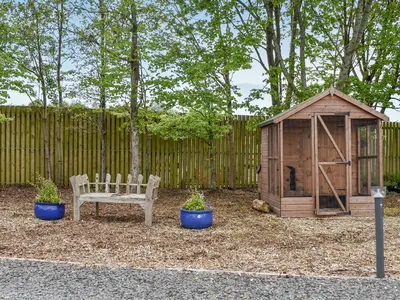 a wooden bench next to a small wooden shed at Oak Lodge - Uk30005 in Lindal in Furness