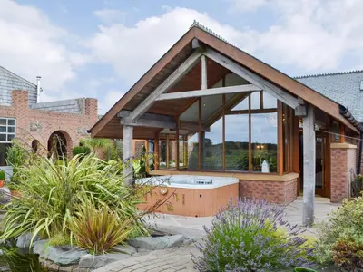 a house with a hot tub in a garden at Carr End Barn A in Preesall