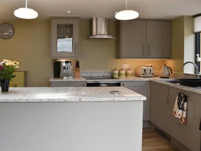 a kitchen with gray cabinets and a counter top at The Bothy in Beetham
