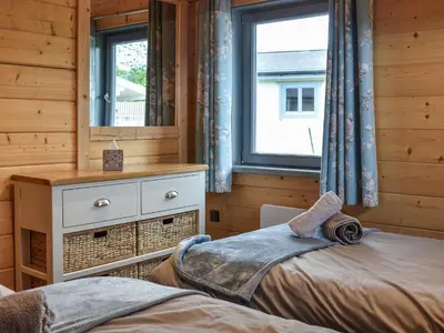 a bedroom with a bed and a dresser and a mirror at Pine Lodge - Uk30007 in Lindal in Furness