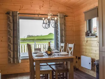 a dining room with a table and chairs and a window at Pine Lodge - Uk30007 in Lindal in Furness