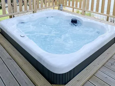 a jacuzzi tub sitting on top of a deck at Larch Lodge - Uk30009 in Lindal in Furness