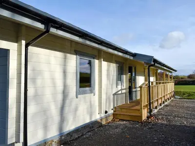 a small house with a porch and a deck at Larch Lodge - Uk30009 in Lindal in Furness