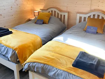 two beds sitting next to each other in a room at Larch Lodge - Uk30009 in Lindal in Furness