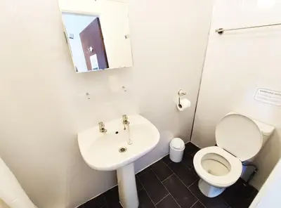 a small bathroom with a toilet and a sink at Mardi Gras Hotel in Blackpool