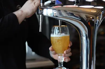 a man is holding a glass of beer at Hotel Anfield in Liverpool