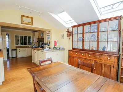 a kitchen with a wooden table and a dining room at The White House in Grange Over Sands