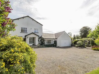 a white house with a gravel driveway at The White House in Grange Over Sands