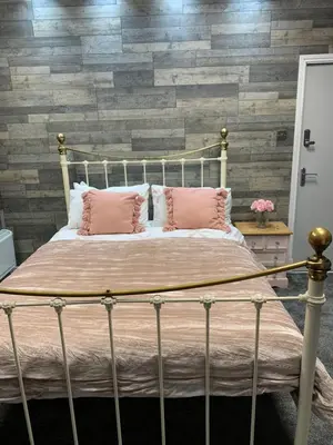 a bedroom with a bed with pink pillows at My Perfect Place Rooms & Apartments -Some rooms with Hot Tub- Free Parking in Blackpool