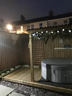a backyard with a wooden fence and a grill at My Perfect Place Rooms & Apartments -Some rooms with Hot Tub- Free Parking in Blackpool