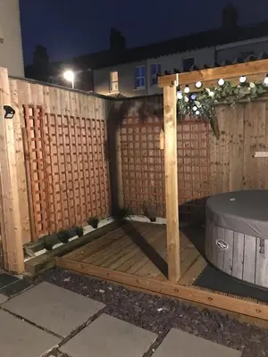 a wooden fence with a table and a barrel at My Perfect Place Rooms & Apartments -Some rooms with Hot Tub- Free Parking in Blackpool