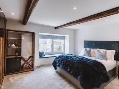 a bedroom with a large bed and a window at Coffee & Stays at Cartmel Square in Cartmel