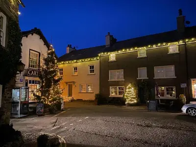 a building with christmas lights on the side of it at Coffee & Stays at Cartmel Square in Cartmel