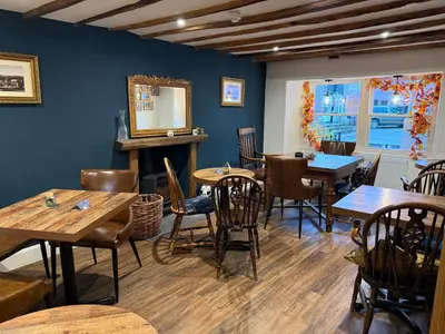 a dining room with wooden tables and chairs at Coffee & Stays at Cartmel Square in Cartmel
