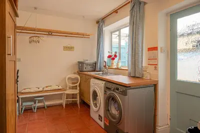 a kitchen with a washing machine and a sink at The Old Post Office in Grange Over Sands