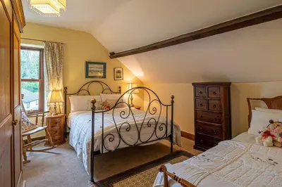 a bedroom with two beds and a window at The Old Post Office in Grange Over Sands